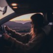 young person driving at dusk